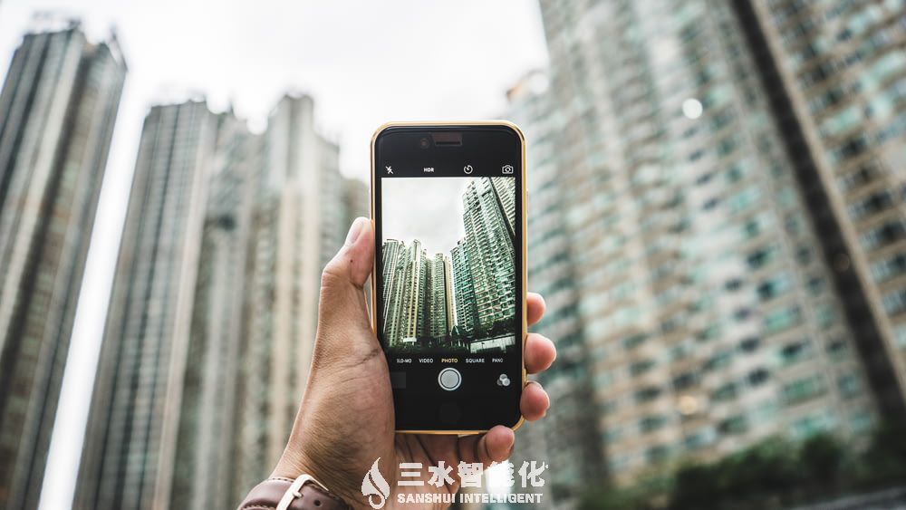 目前建筑能耗监测存在哪些问题?该如何完善?(图1) person using smartphone taking picture of building.jpg